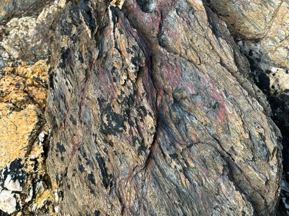 Weathered rock on the Devon coast, banded in rust, grey and ochre